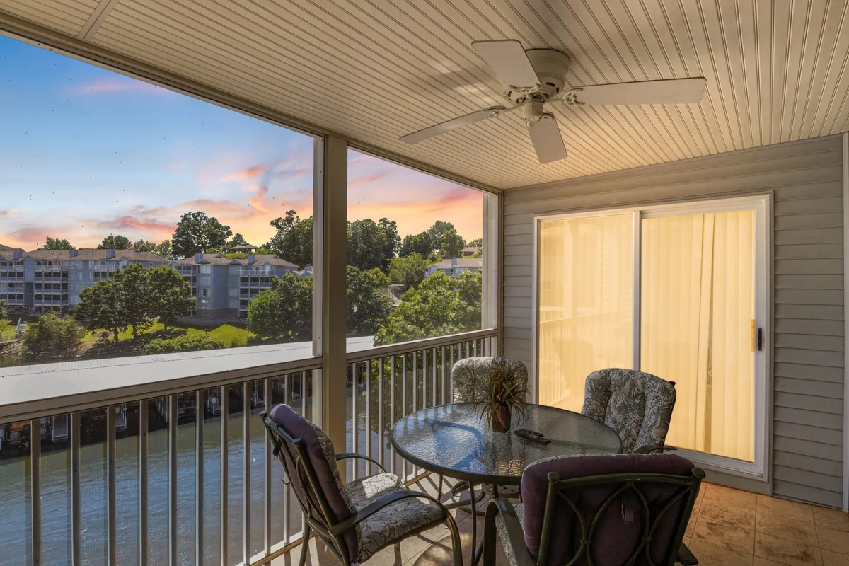 An inviting outdoor dining space featuring a table, ceiling fan, and expansive views over the landscape. The area is set up for meals or quiet moments outdoors, with plenty of natural light and a peaceful atmosphere ideal for enjoying coffee, reading, or evening drinks while overlooking the lake.